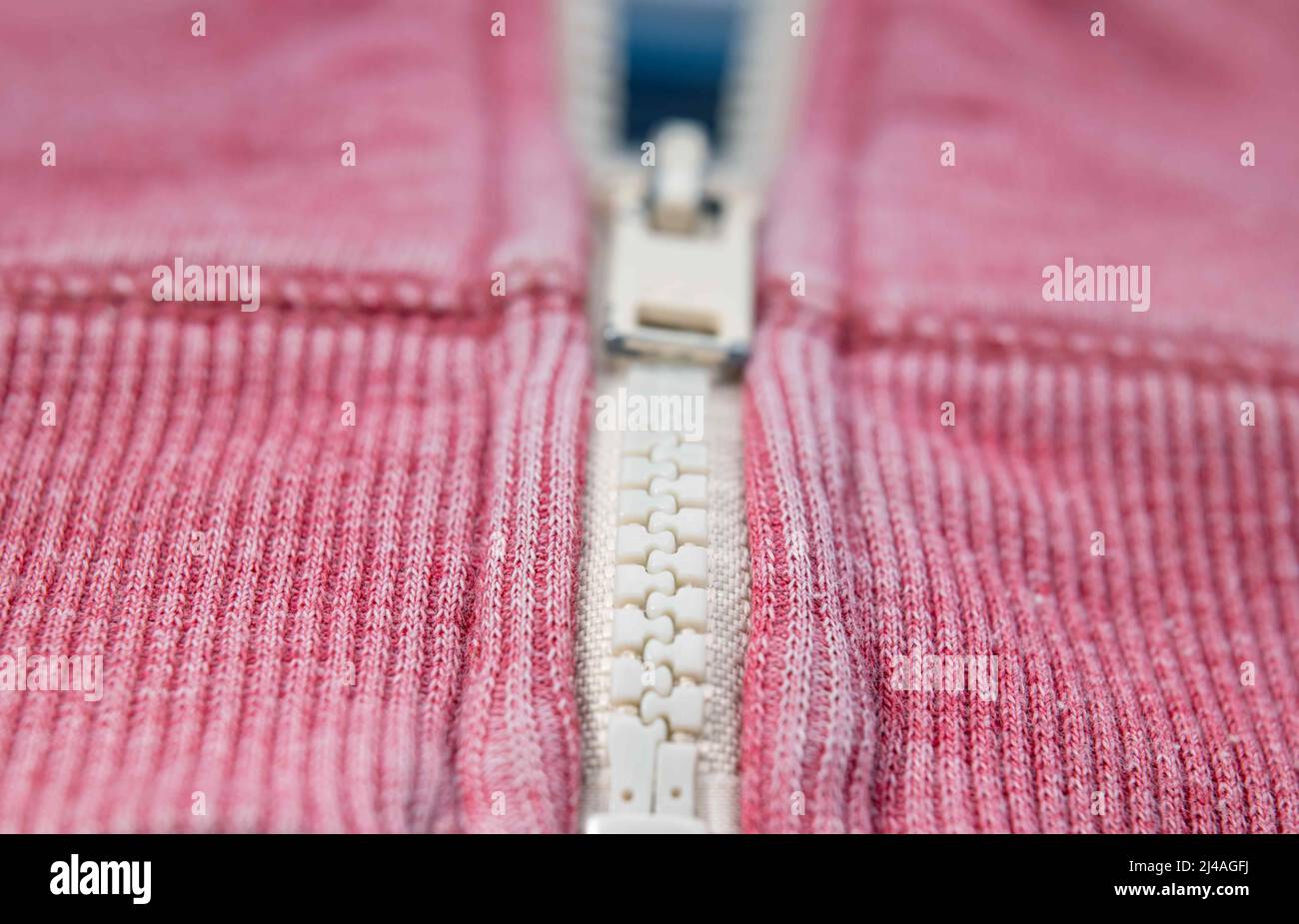 Worn, faded red jacket with zipper, close up Stock Photo
