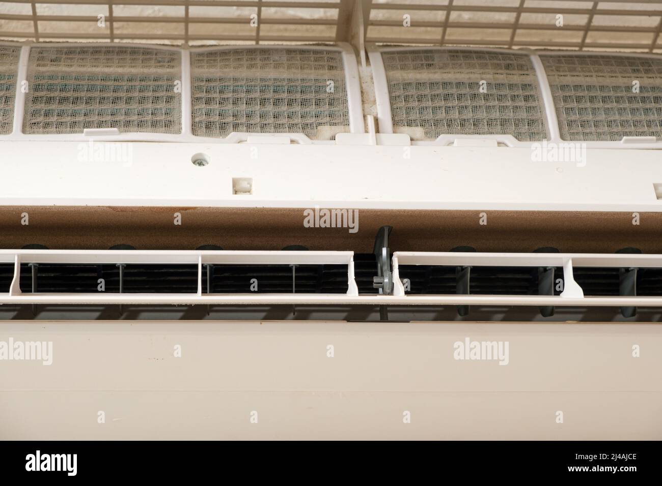 Air conditioner with open lid, dirty filters in the dust are visible