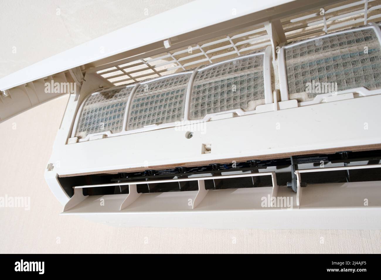 Air conditioner with open lid, dirty filters in the dust are visible