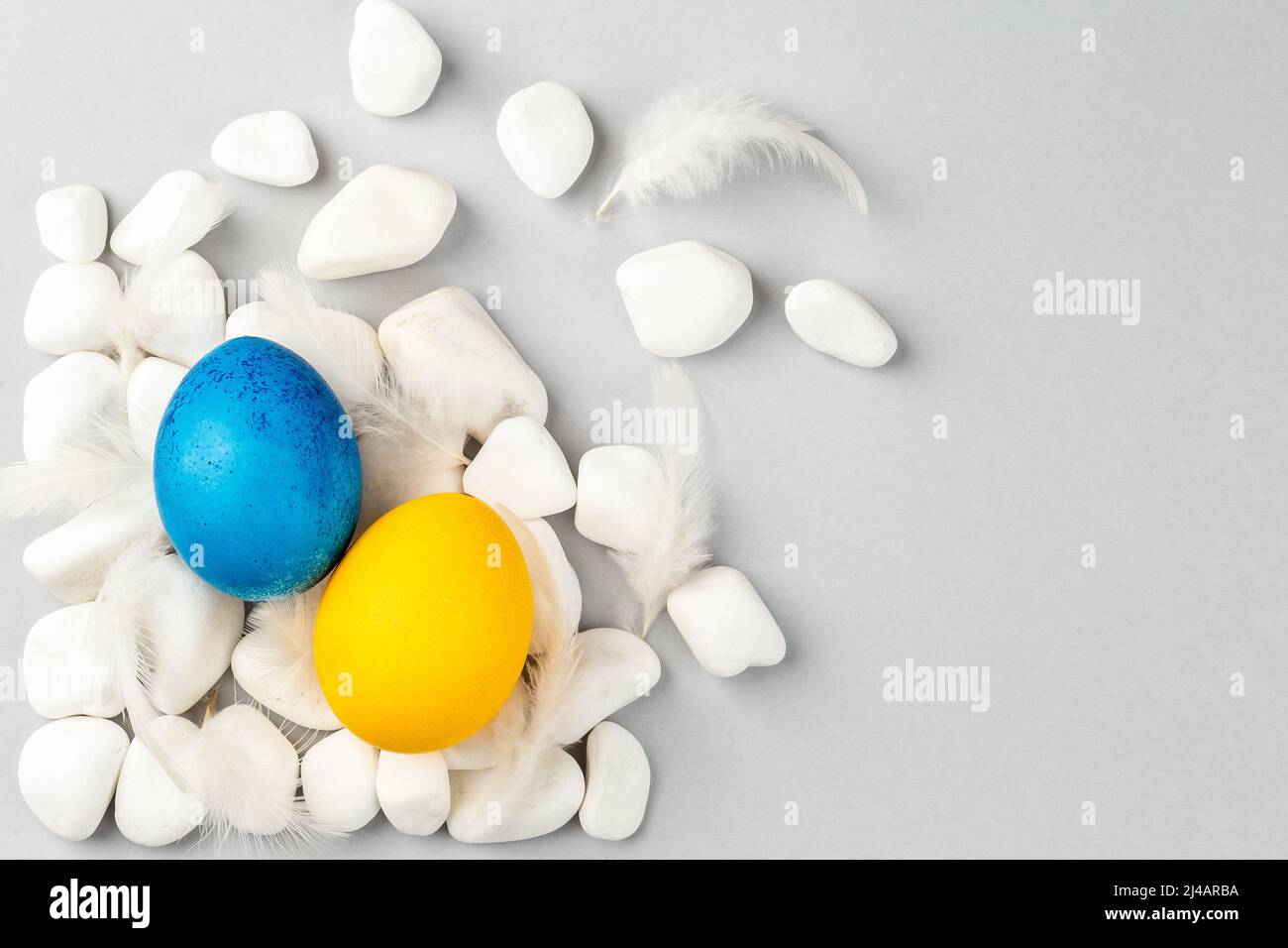 Blue and Yellow Ukrainian Easter Eggs on the rocks scattered on the ...