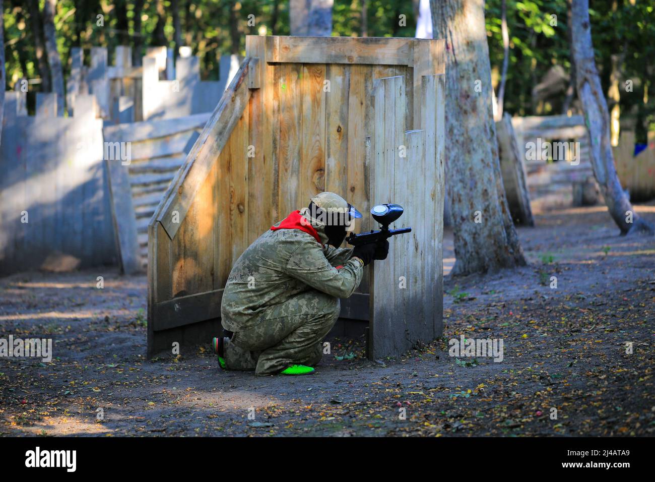 Paintball player in full gear shoots at the shooting range Stock Photo