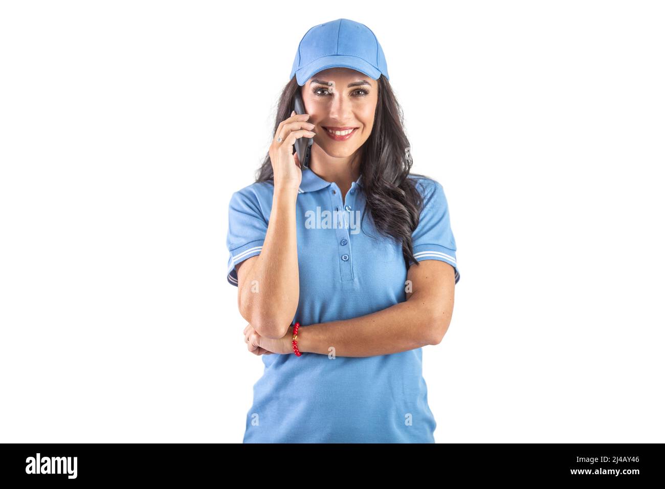 Attractive dark-haired delivery woman in blue uniform calling to a customer. Isolated white background. Stock Photo