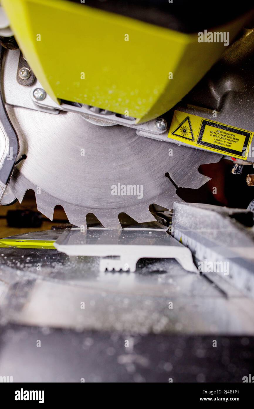 Worker cutting baseboard on the circular saw before installing Stock