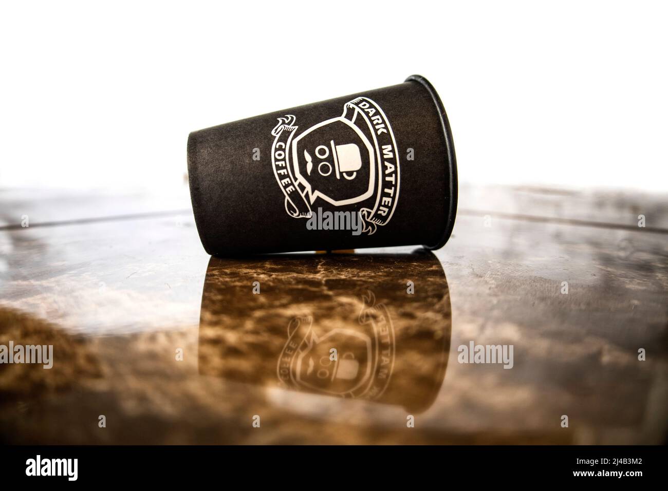 13.04.2022. Kyiv/ Ukraine/ Paper cup of coffee on the ground. Inscription dark matter coffee. Stock Photo