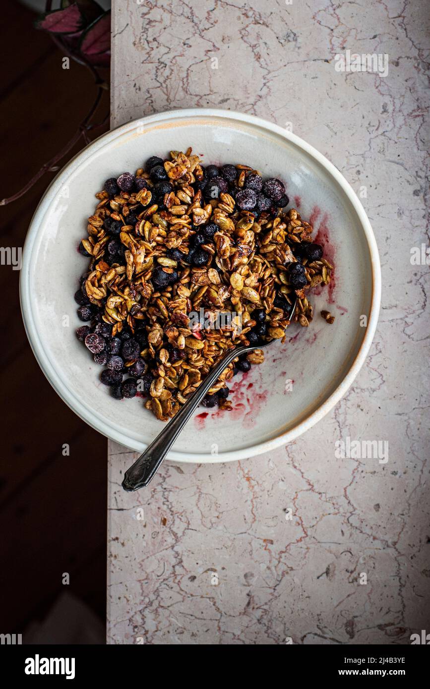 Blueberry Granola in a bowl on a marble worktop Stock Photo