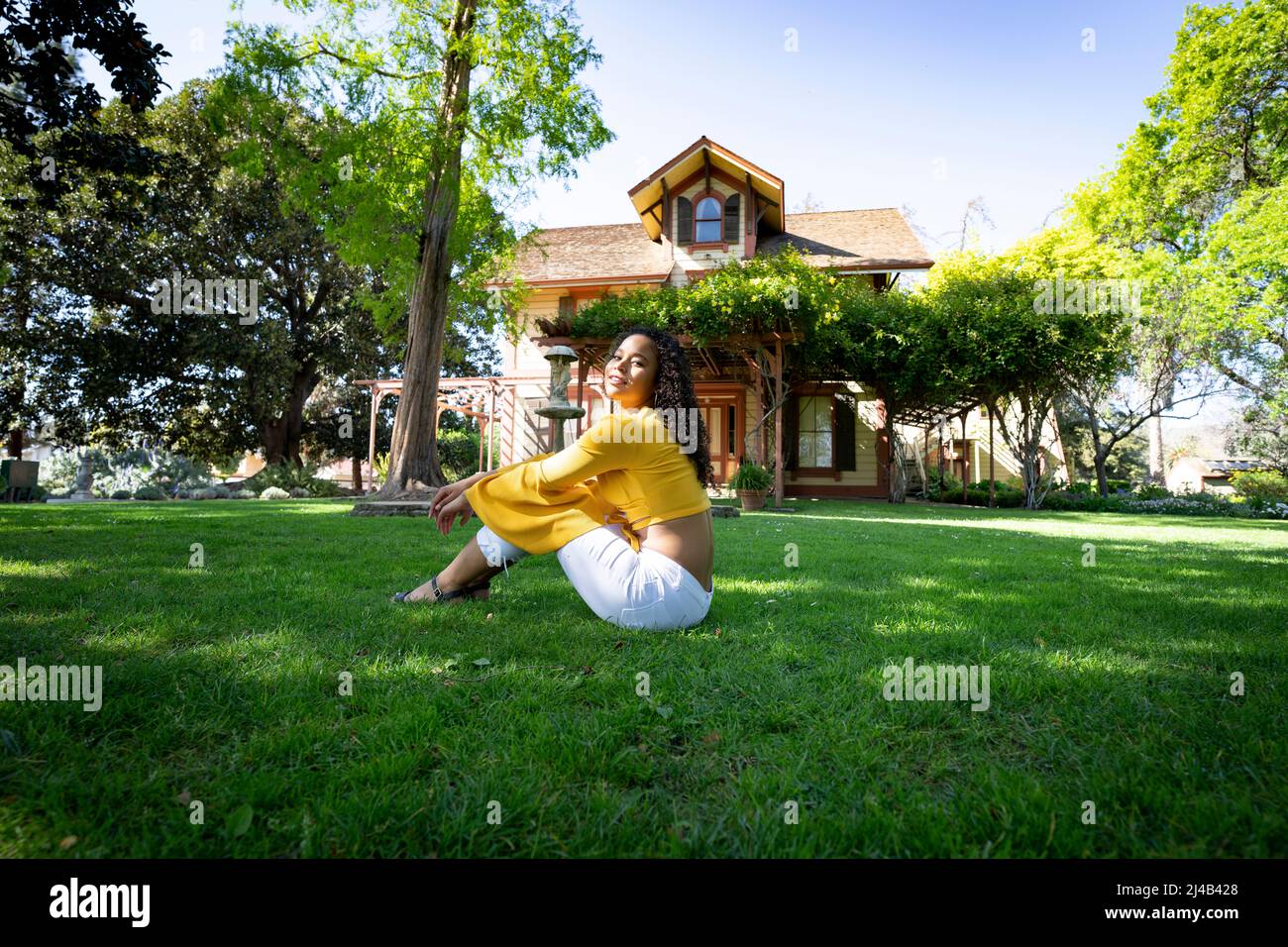 Portrait of a Vibrant Young Black Woman in Front of an Old Victorian House Stock Photo