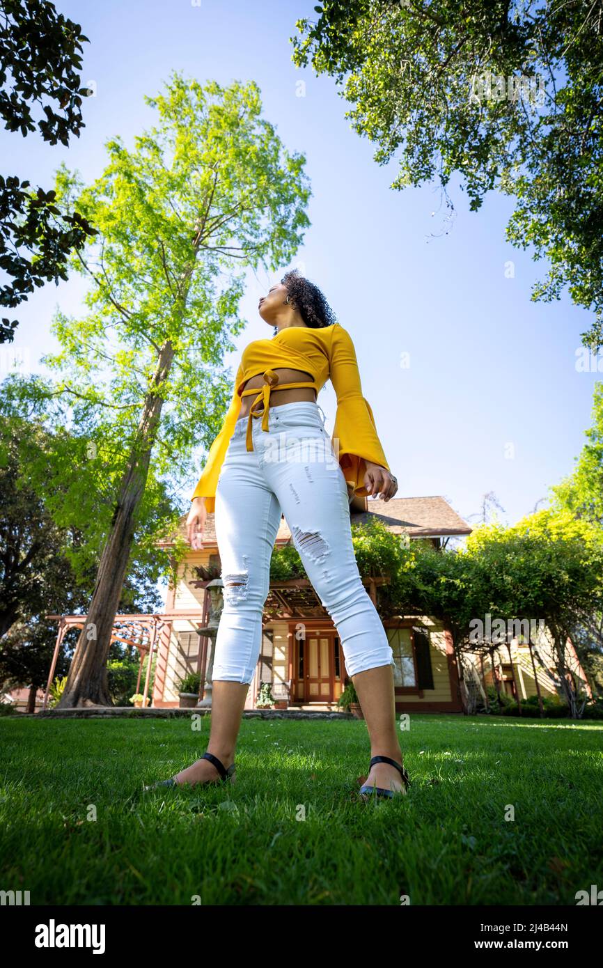 Portrait of a Vibrant Young Black Woman in Front of an Old Victorian House Stock Photo