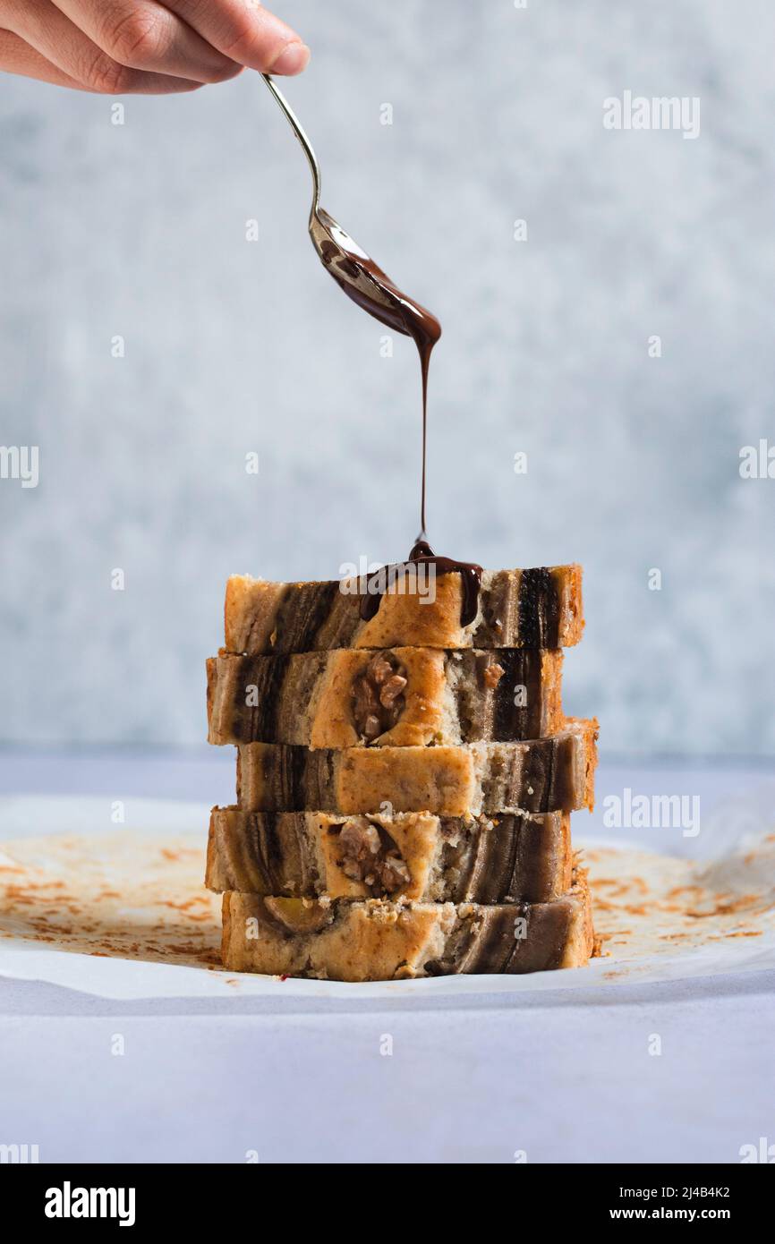 Banana bread with melted chocolate being poured over it Stock Photo