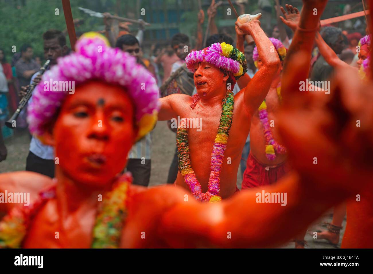Munshiganj, Bangladesh. 13th Apr, 2022. Hindu devotees seen dancing during the Lal Kach procession on the last day of Bangla year. The Lal Kach (Red Galss) festival is celebrated in the local community for many decades. The Hindu men paint themselves with red color and attend a procession holding swords as they show power against evil sprits while ending a year and welcoming another Bangla New Year. Credit: SOPA Images Limited/Alamy Live News Stock Photo