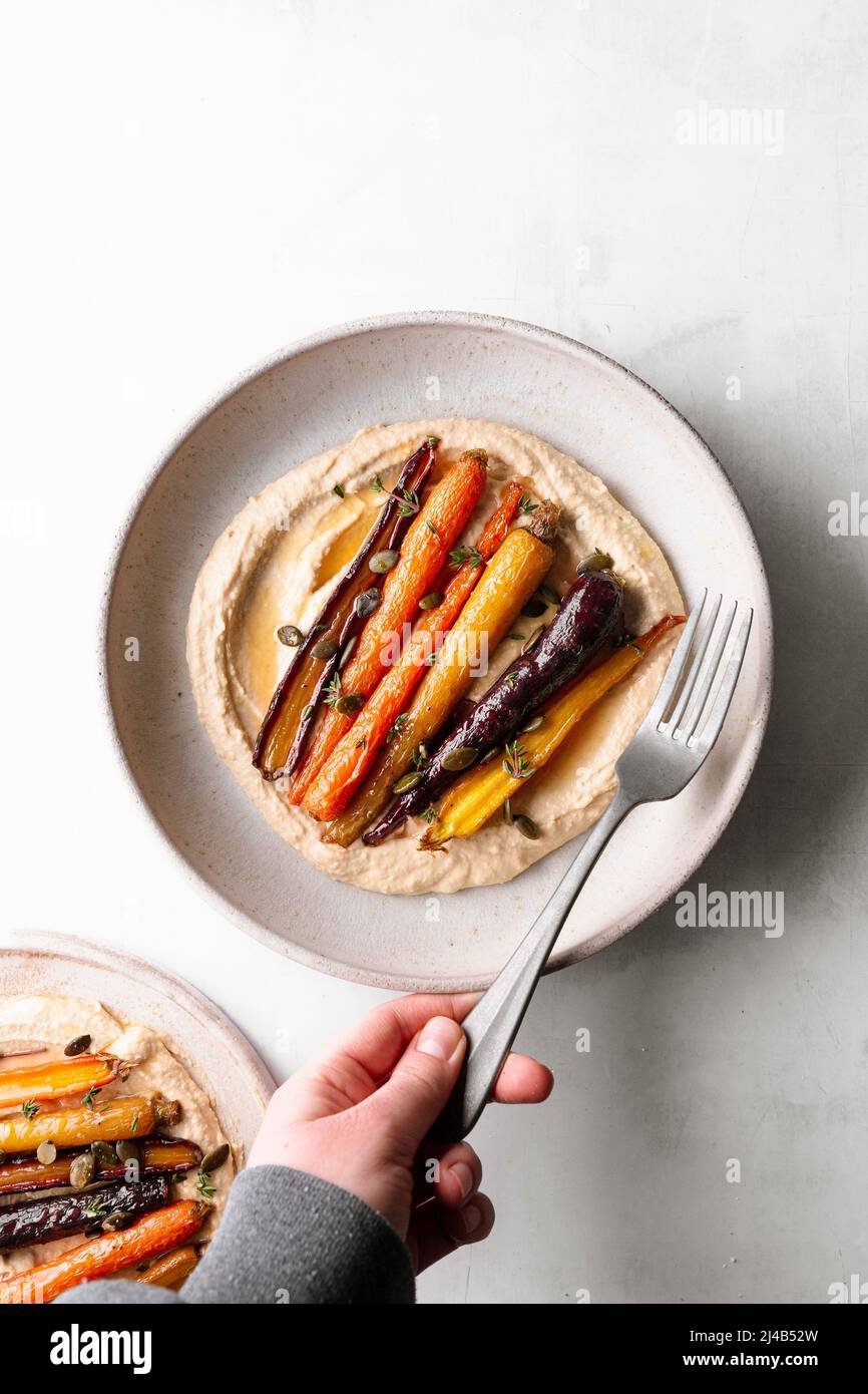 Honey roasted carrots with hummus in a ceramic bowl Stock Photo Alamy