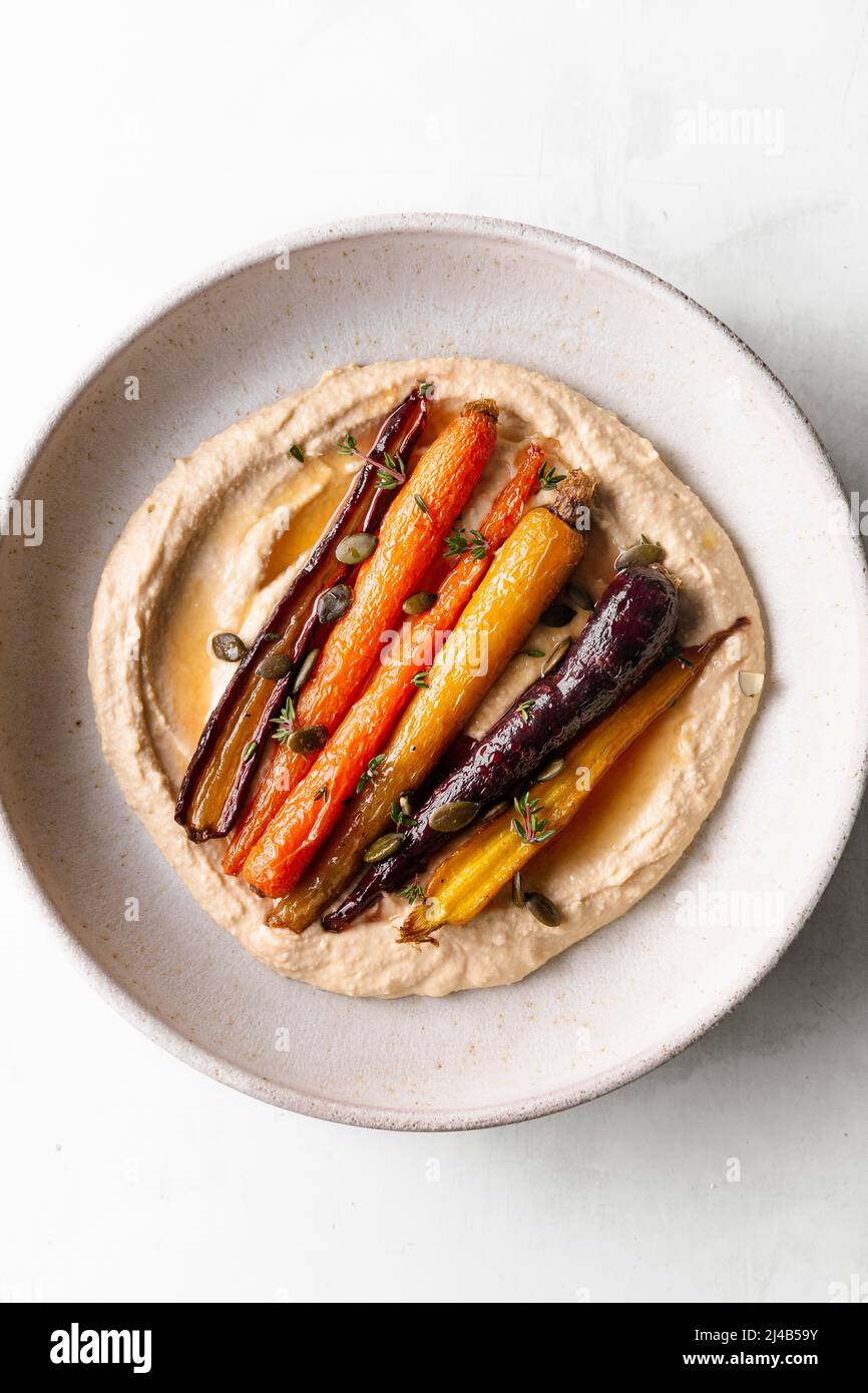 Honey roasted carrots with hummus in a ceramic bowl Stock Photo Alamy