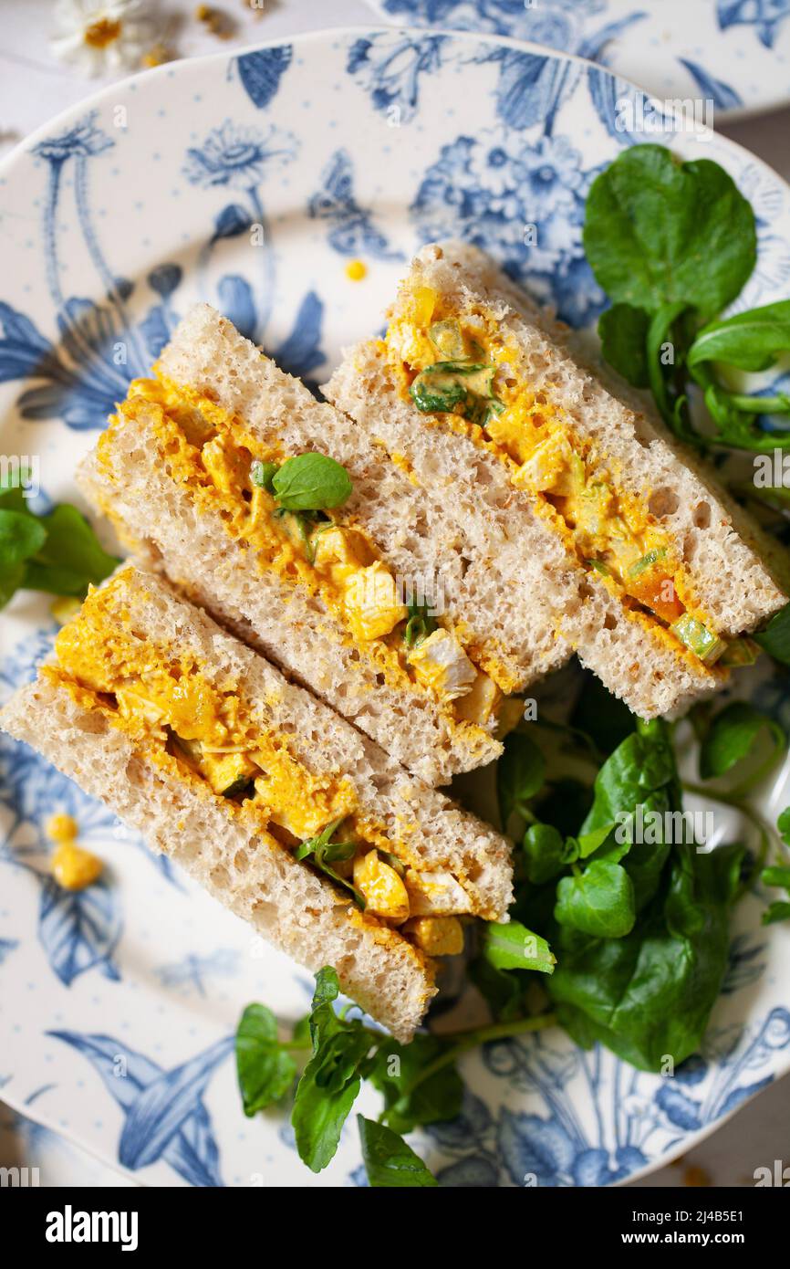 https://c8.alamy.com/comp/2J4B5E1/a-plate-of-finger-sandwiches-filled-with-coronation-chiicken-and-garnished-with-watercress-2J4B5E1.jpg