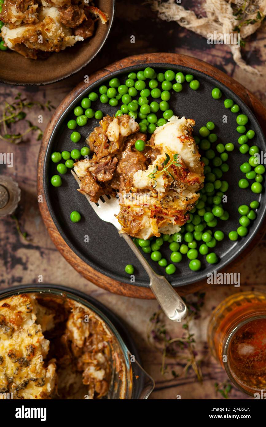 A portion of steak and stilton cheese pie served with peas. Stock Photo