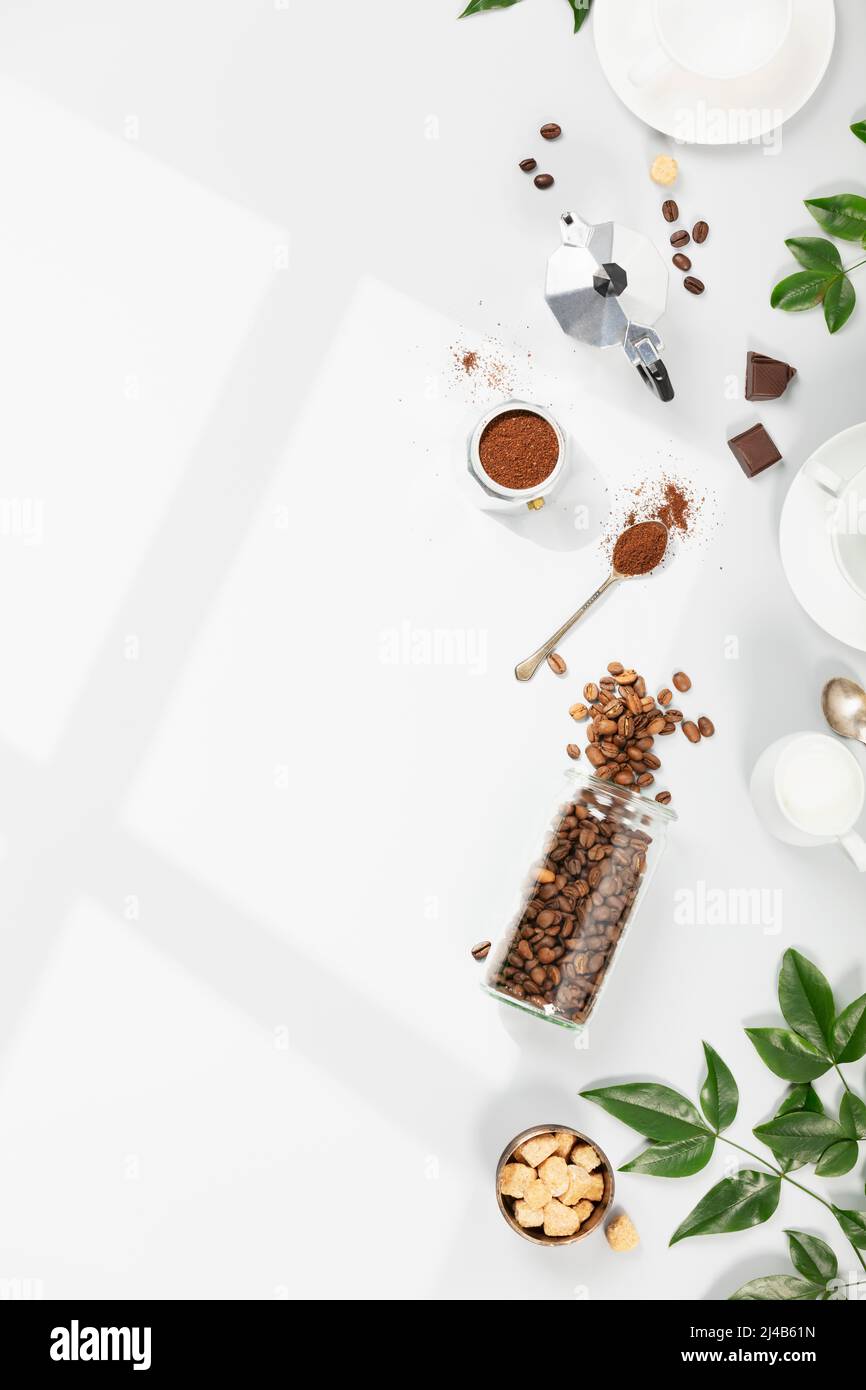 Coffee composition on light grey background, window shadow and green branches, flat lay Stock Photo