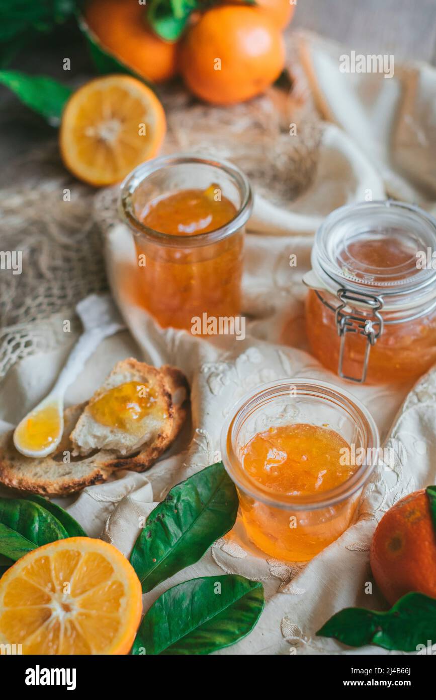 Homemade Seville Orange Marmalade in a jar with sliced oranges Stock Photo