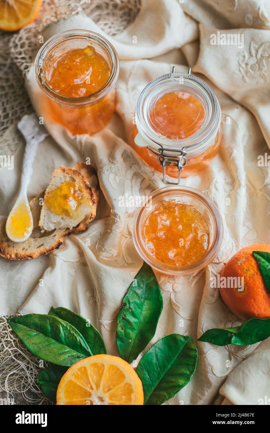Homemade Seville Orange Marmalade in a jar with sliced oranges Stock
