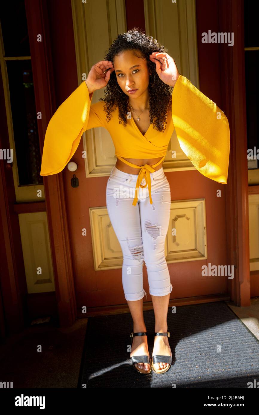 Portrait of a Colorful Young Black Woman in Victorian Doorway Stock Photo