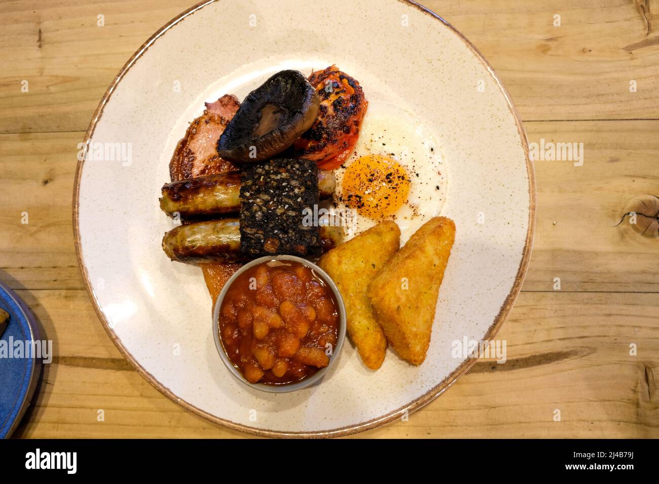 A full english breakfast with sausage bacon egg beans hash brown tomato Stock Photo