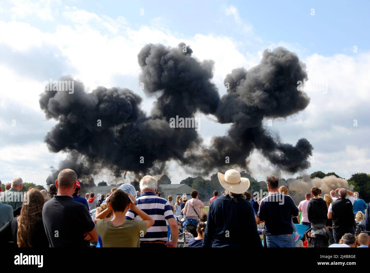 A mock explosion at an air show with lots of smoke and loud bangs to illustrate war-like conditions in a safe manner, Biggin Hill Stock Photo
