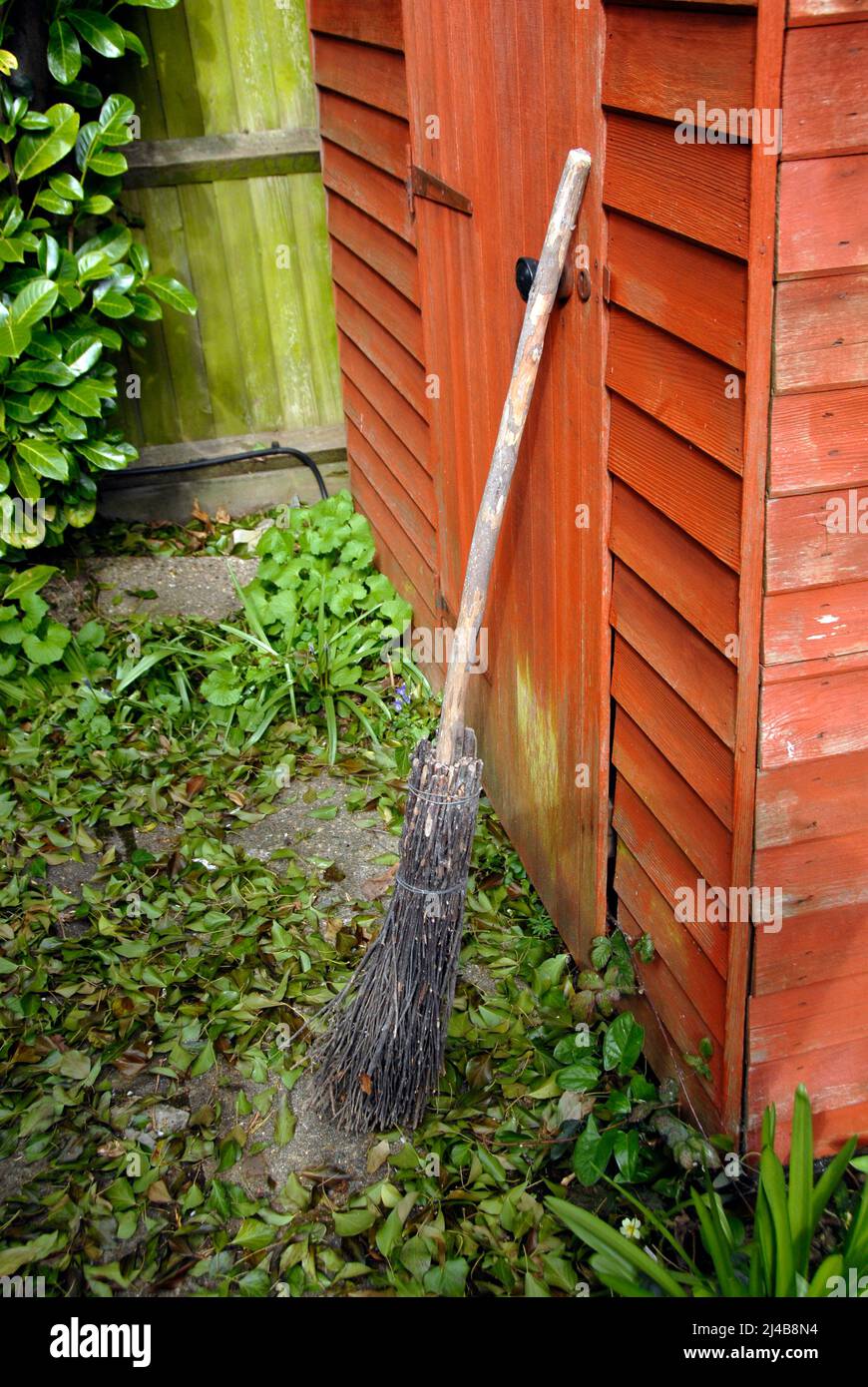 Besom broom leaning against wooden garden shed Stock Photo