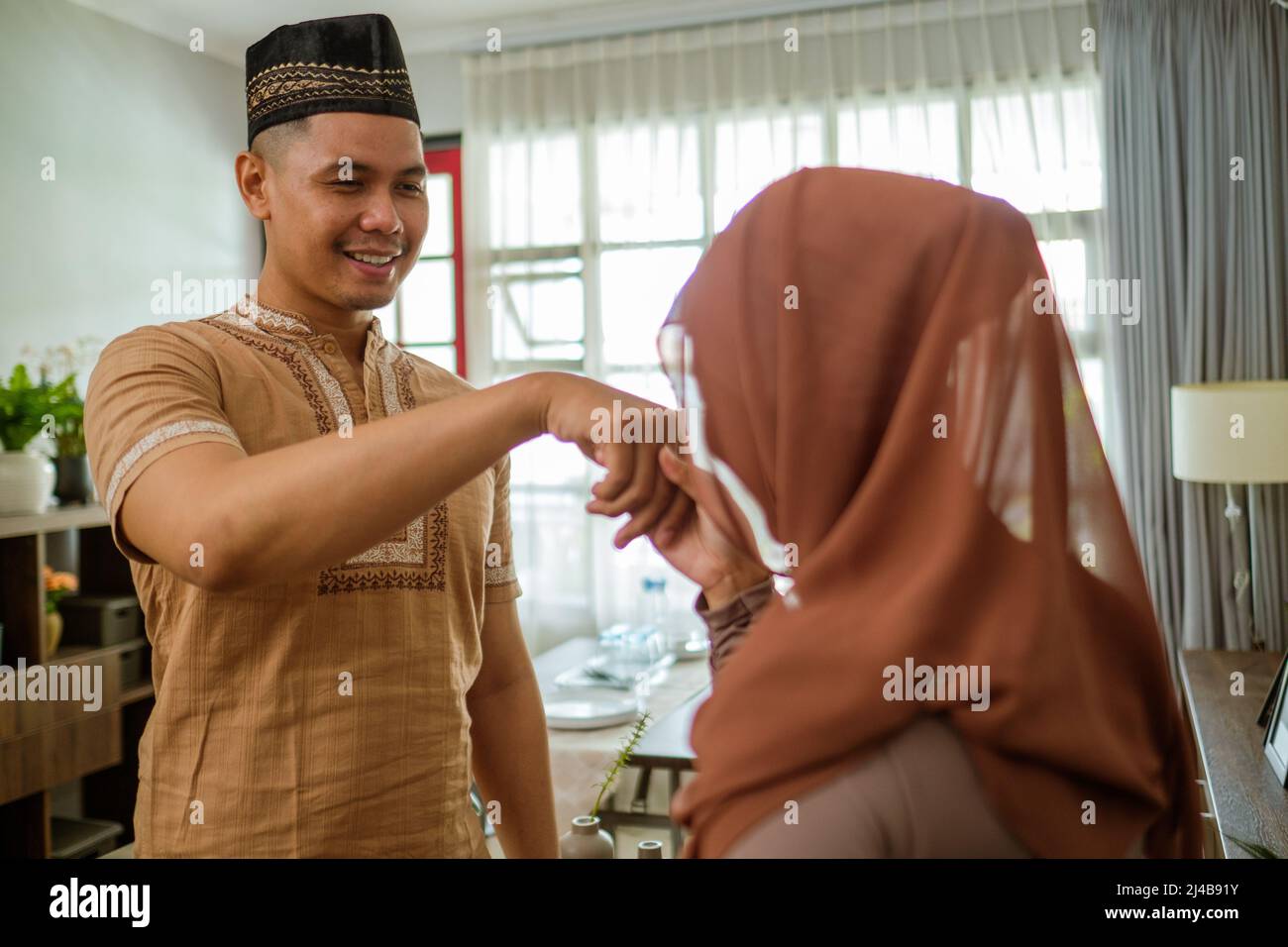 muslim woman shake hand and kiss her husband's hand Stock Photo Alamy