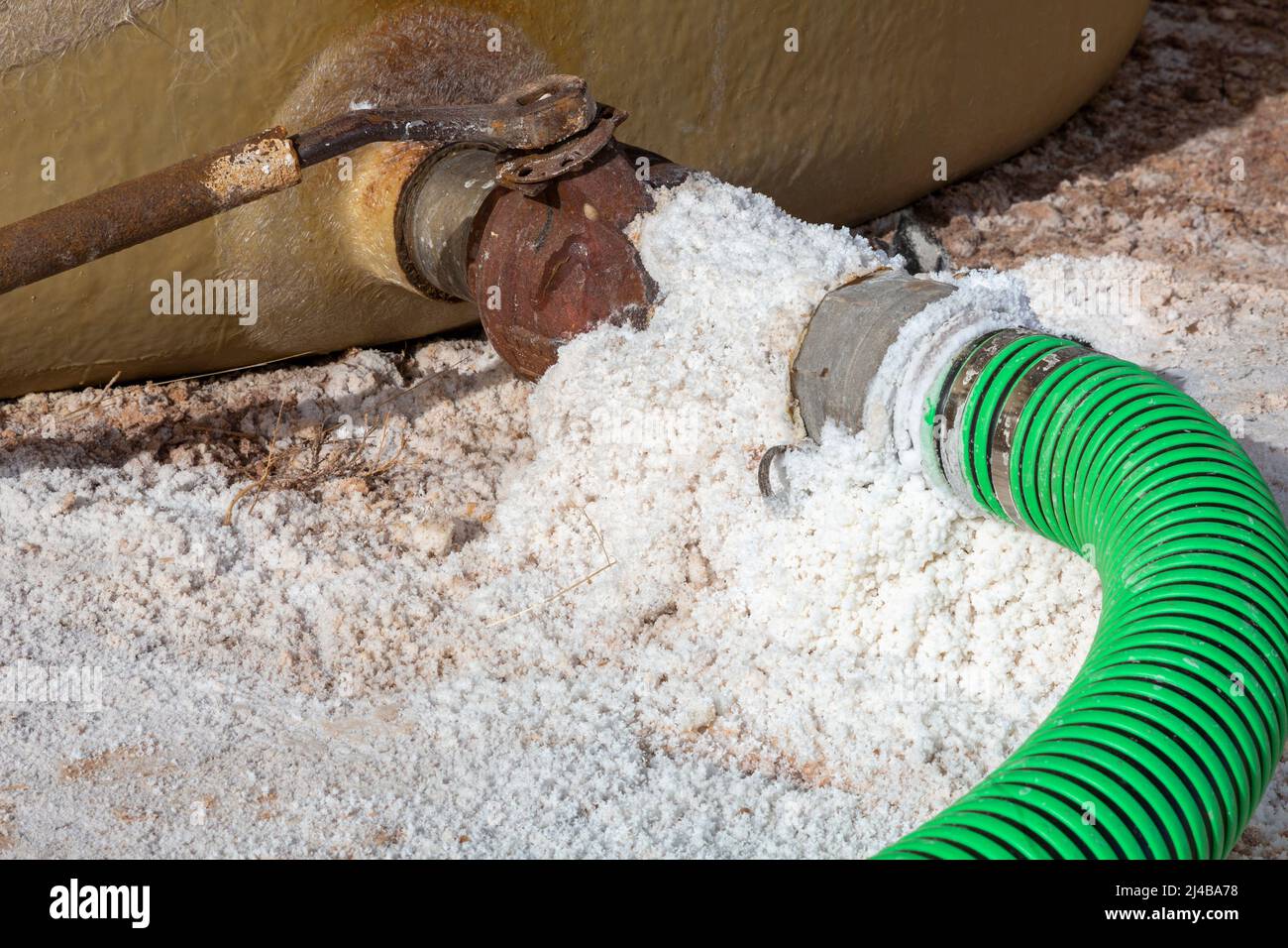 Freedom, Oklahoma - Crystals of salt around hoses connected to tanks holding heavy brine water. Brine, also called produced water, is often a byproduc Stock Photo