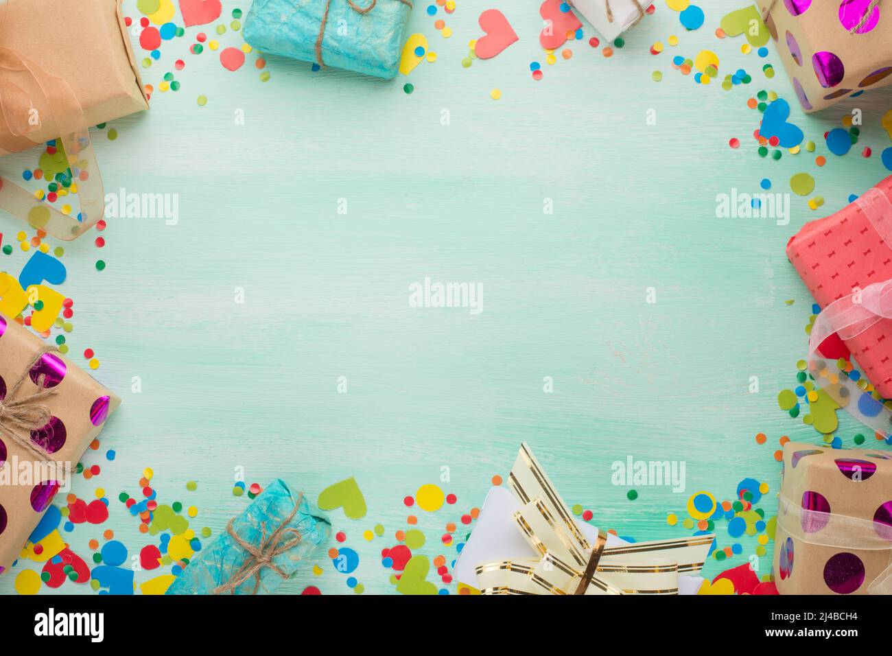 A frame of gifts and confetti with a blank space in the center for an ...