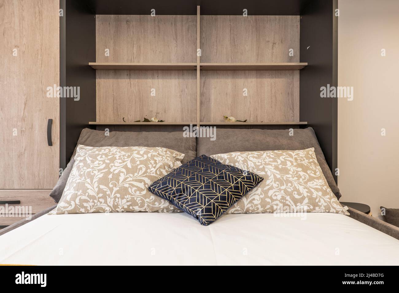 Headboard of a sofa bed with cushions of various colors and width, gray