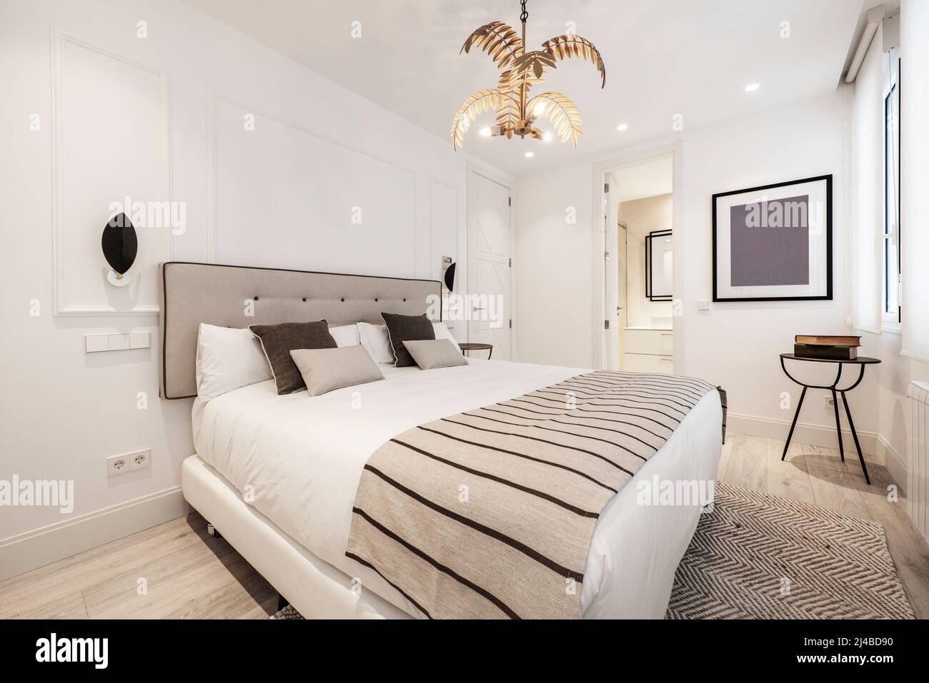 Double bed with upholstered headboard in matching fabric with blankets