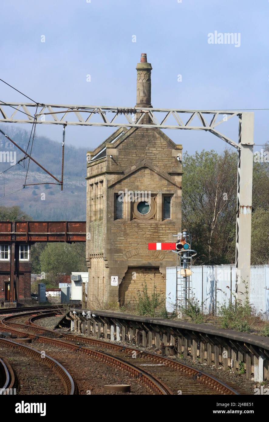 Disused old Midland railway stone signalbox on the end of Carnforth station platform 2 with red semaphore signal and track. Stock Photo