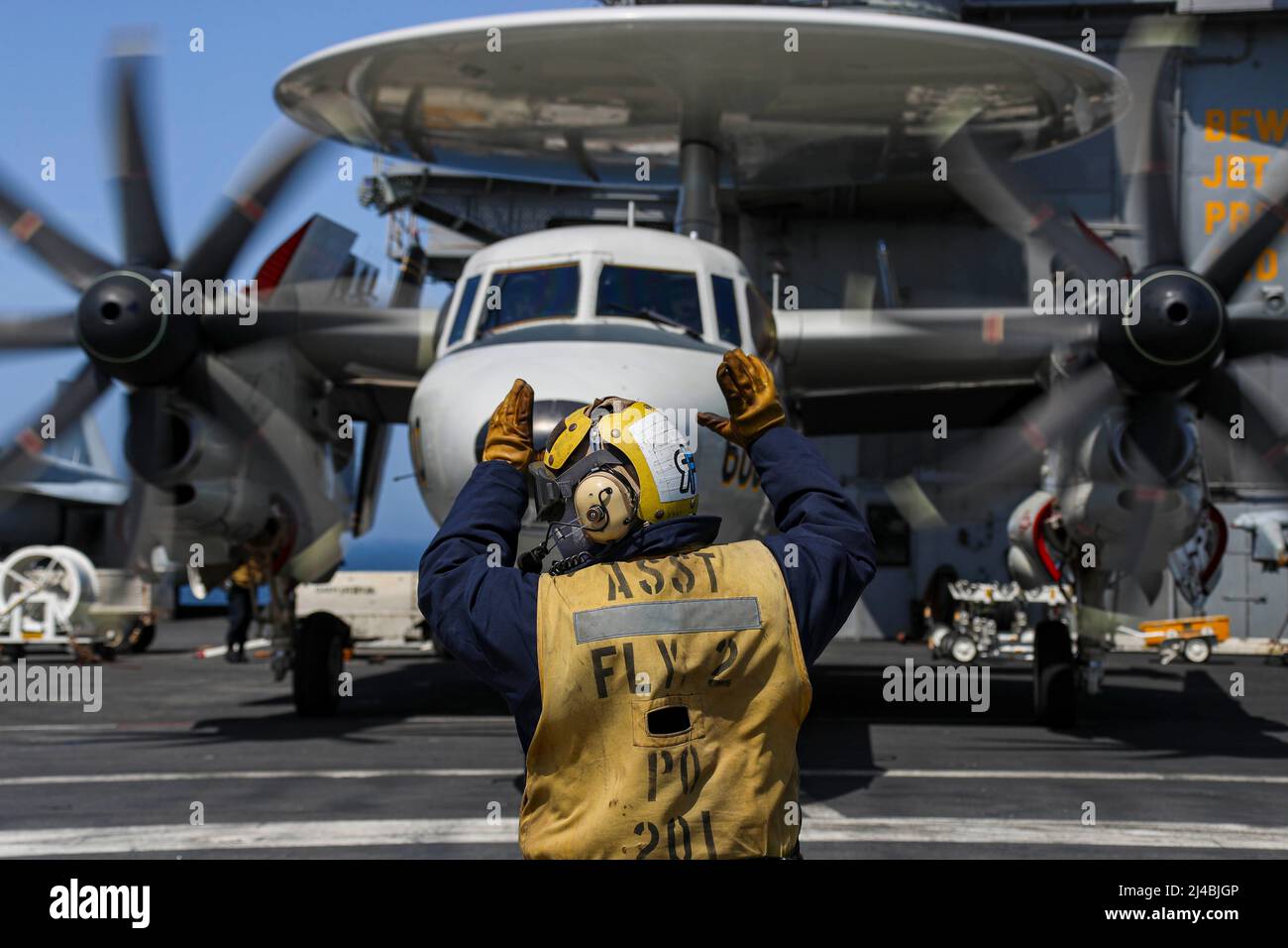220412-N-VI910-1118  SEA OF JAPAN (April 12, 2022) Aviation Boatswain’s Mate (Handling) 1st Class Melvin Dominguez, from Tujunga, California, directs an E-2D Hawkeye, assigned to the 'Wallbangers' of Carrier Airborne Early Warning Squadron (VAW) 117, on the flight deck of the Nimitz-class aircraft carrier USS Abraham Lincoln (CVN 72) during a U.S.-Japan bilateral exercise. During bilateral exercises between Abraham Lincoln Carrier Strike Group and Japan Maritime Self-Defense Force (JMSDF), the two navies strengthen all-domain awareness and maneuvers across a distributed maritime environment. Stock Photo