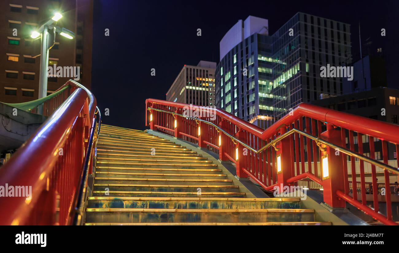 Red railings on empty stairs going up towards office skyscrapers at ...