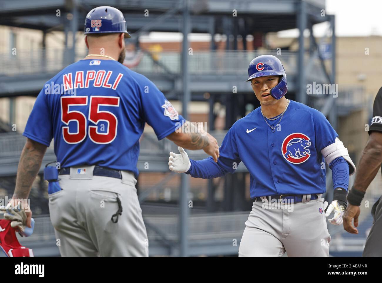 The Chicago Cubs' Seiya Suzuki (R) is congratulated by first base