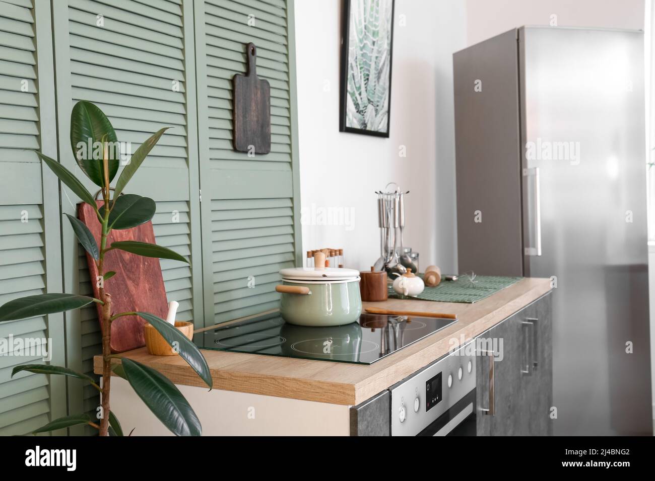 Electric stove with pot and utensils on counter in modern kitchen Stock Photo Alamy