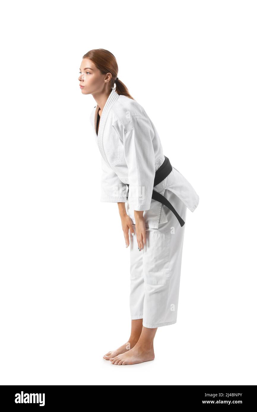 Female karate instructor performing ritual bow on white background