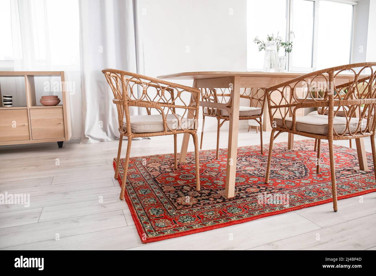 Interior of light dining room with table and vintage carpet Stock Photo Alamy