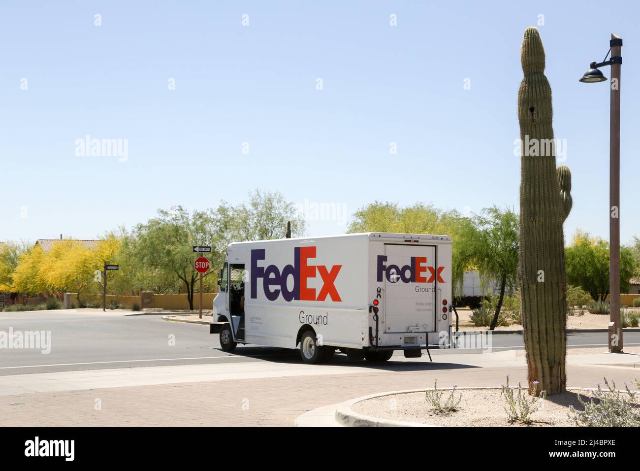 A FedEx Ground delivery truck exits a gated community in Mesa, Arizona USA  on April 13, 2022. FedEx is the only delivery company to classify drivers  as independent contractors rather than employees.