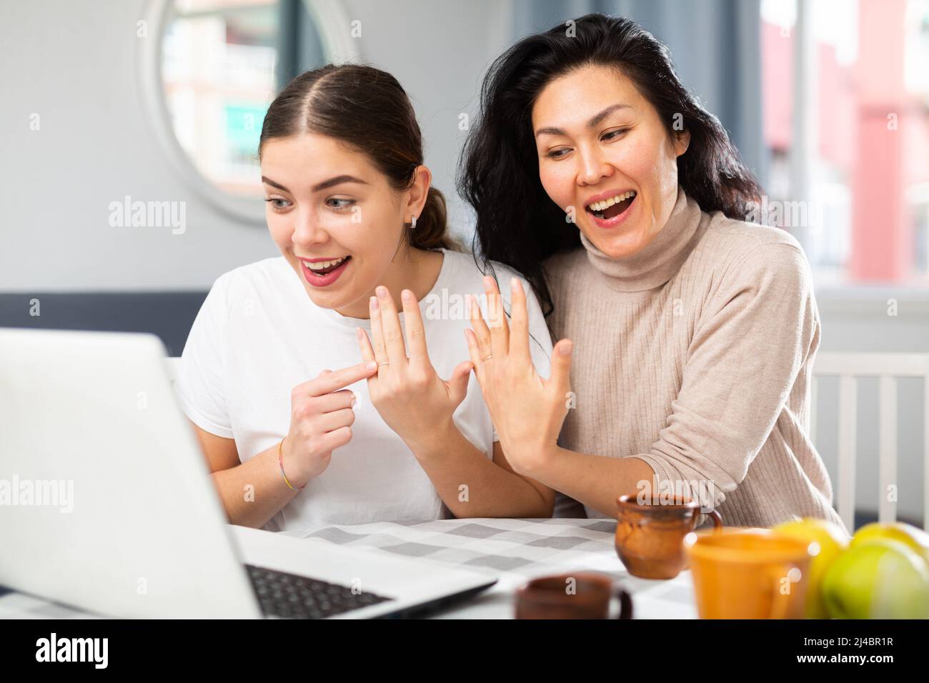 Two women informing friends about marriage online Stock Photo