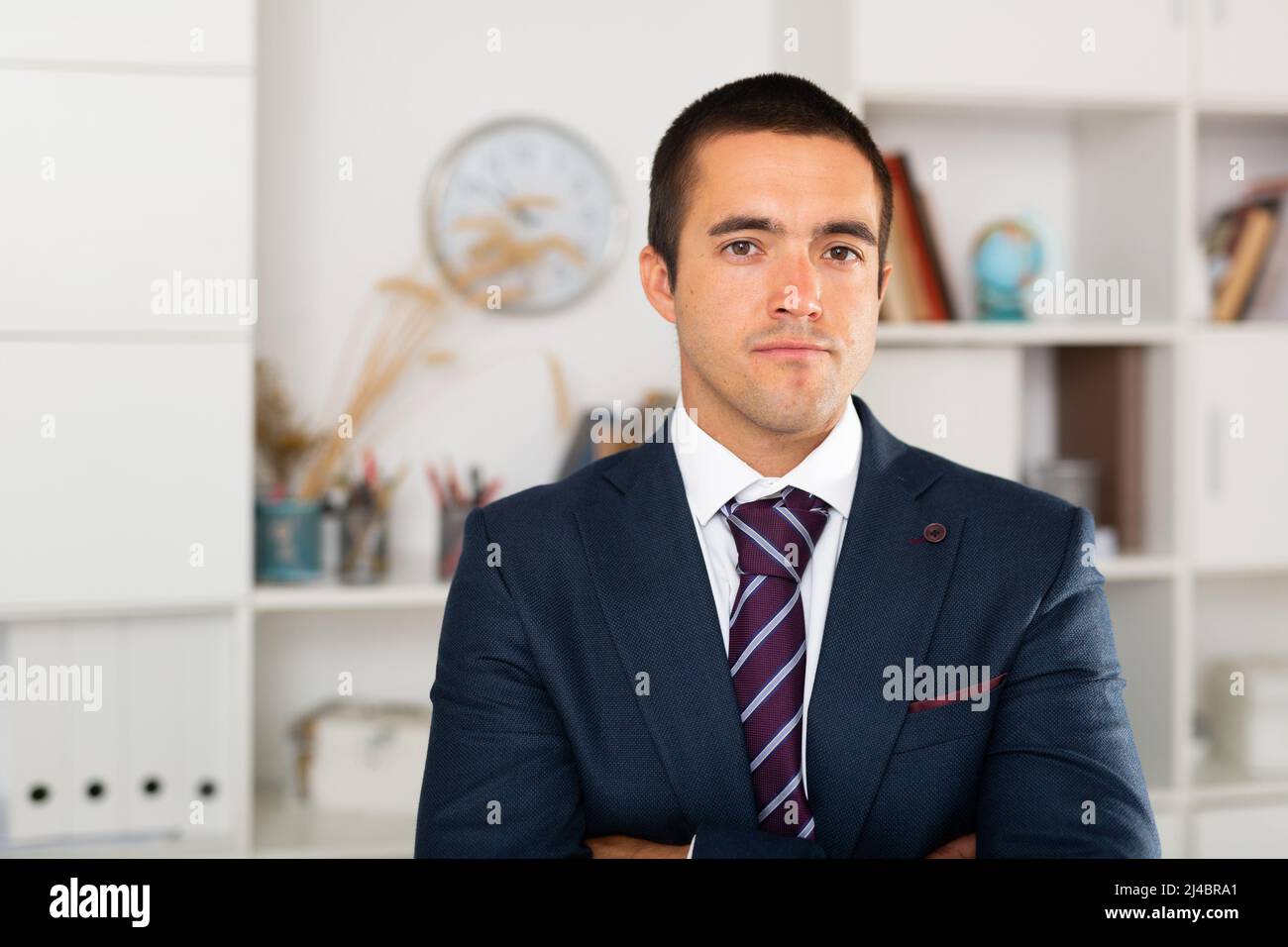 Successful businessman with arms crossed in office interior Stock Photo ...