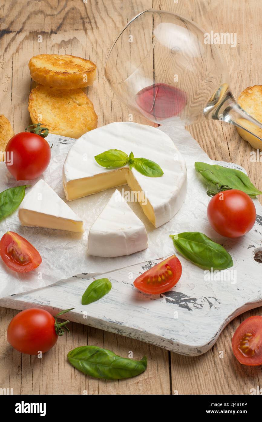 Camembert cheese, basil, cherry tomato, and a glass of red wine Stock ...
