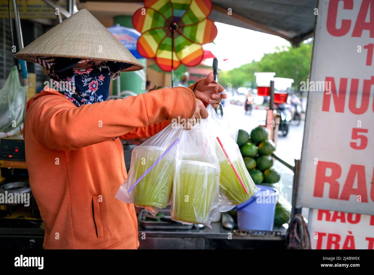 Ho Chi Minh City, Vietnam, April 13, 2022 Woman squeezing sugarcane