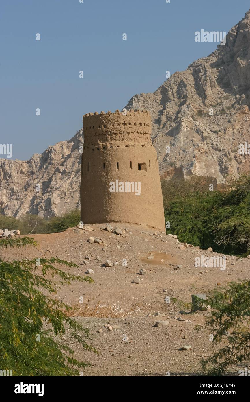 An old watchtower seen against the Hajar Mountains at Dhayah, in the Emirate of Ras al Khaimah, in the United Arab Emirates. Stock Photo