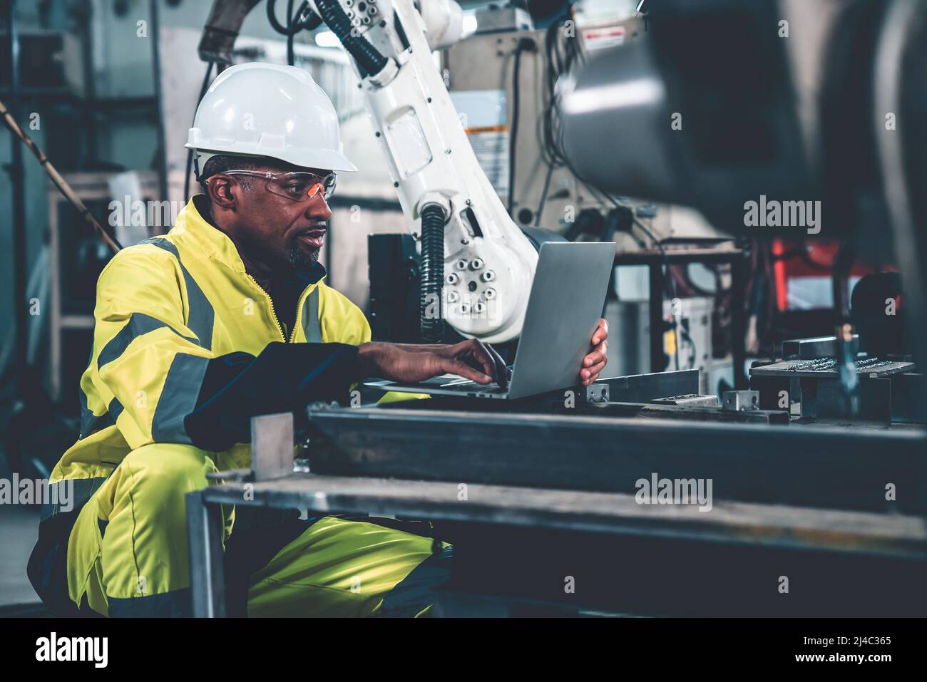 Factory worker working with laptop computer to do adept procedure