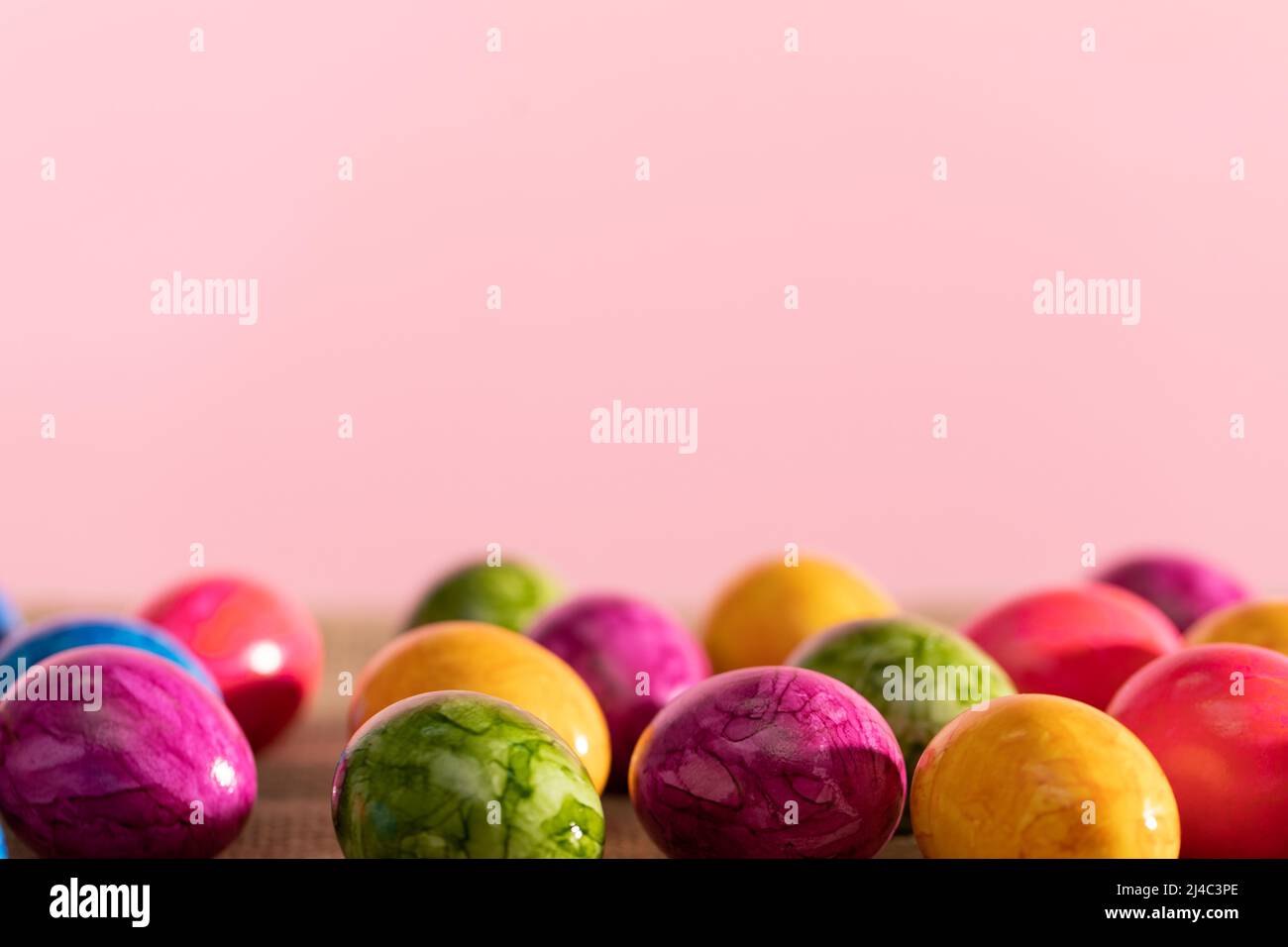 Scattered colored chicken eggs on linen fabric. Easter. Stock Photo