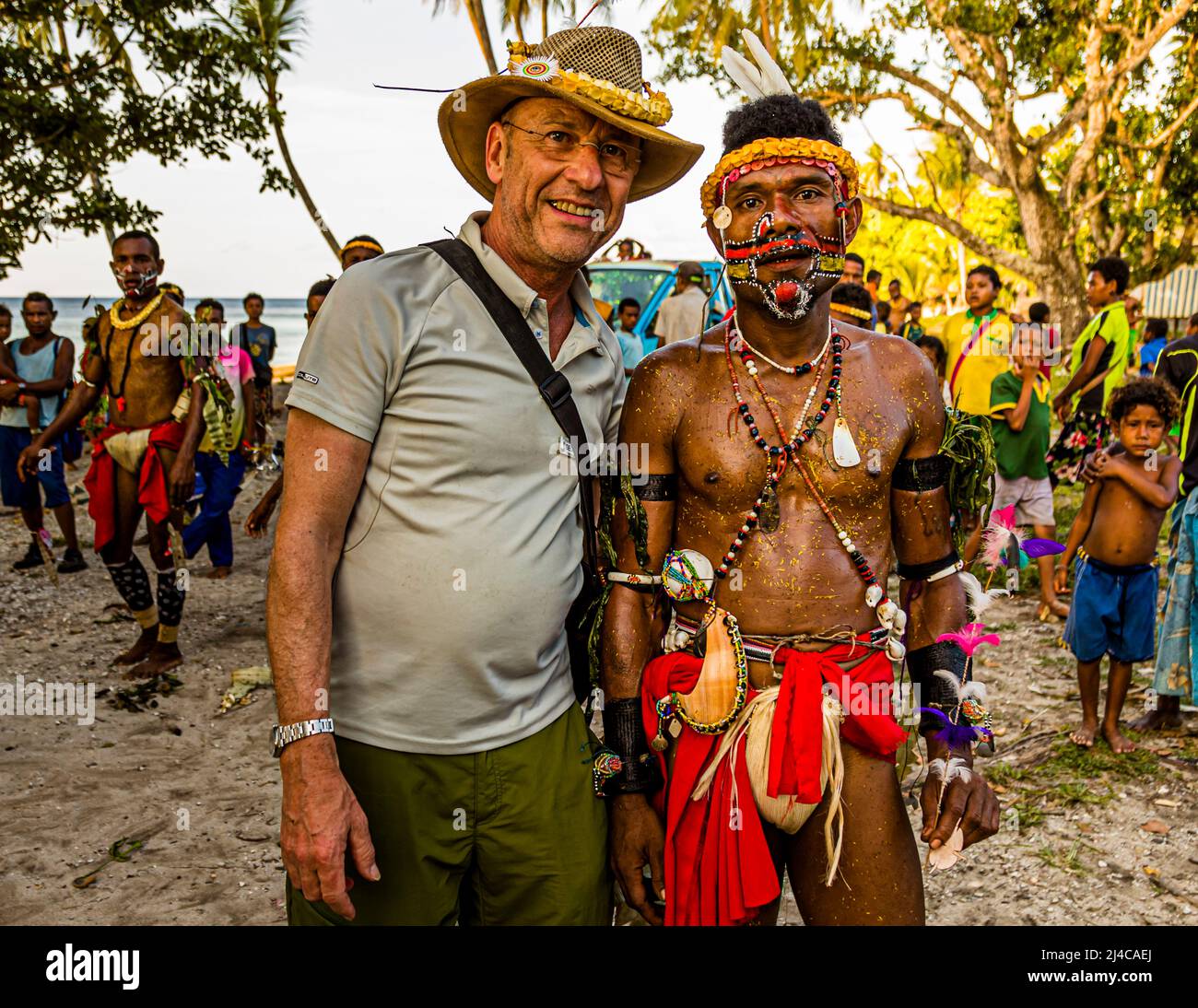 Reporter Georg Berg poses for a souvenir photo for the ship's pinboard with the victorious team leader after the cricket match played by Trobriand rules in Kwebwaga, Trobriand Islands, Papua New Guinea. Stock Photo