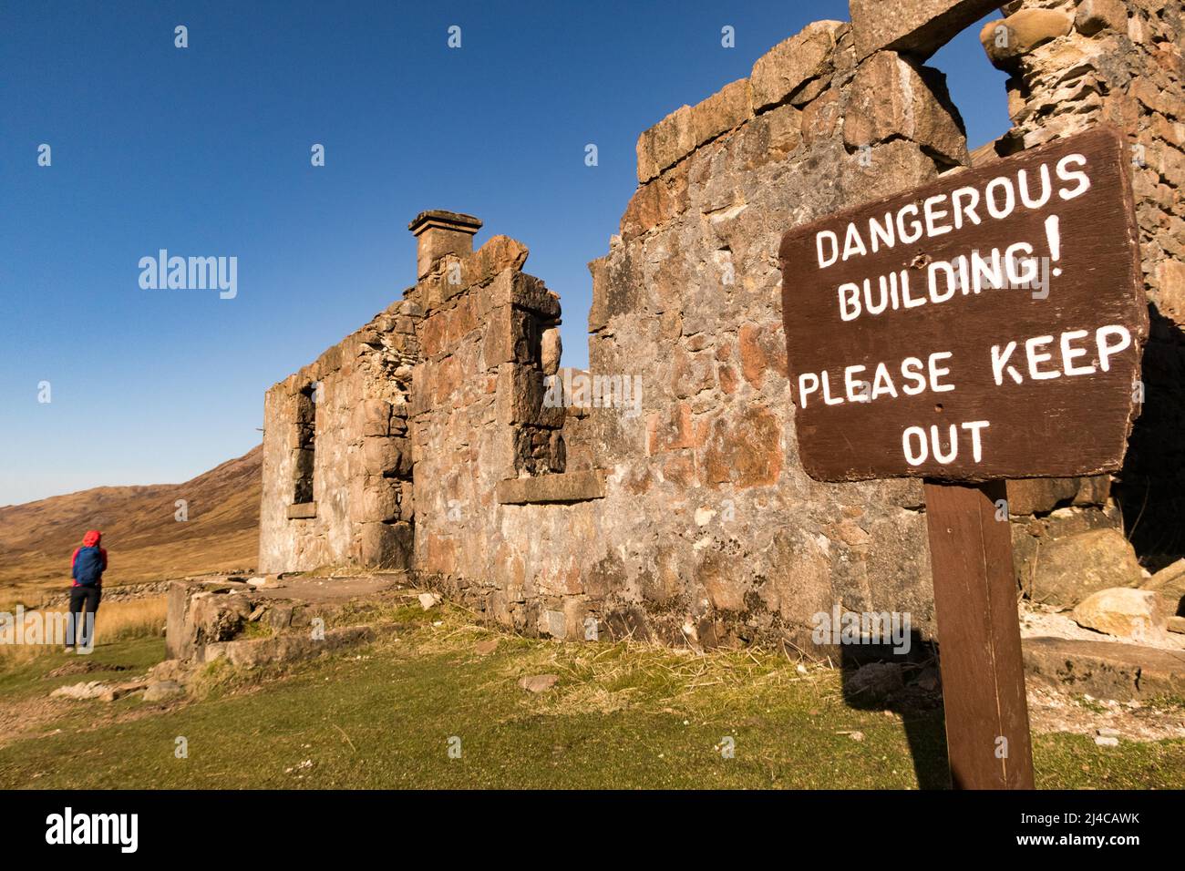 A walker approaching an abandoned building in the Scottish Highlands along the West Highland Way Stock Photo