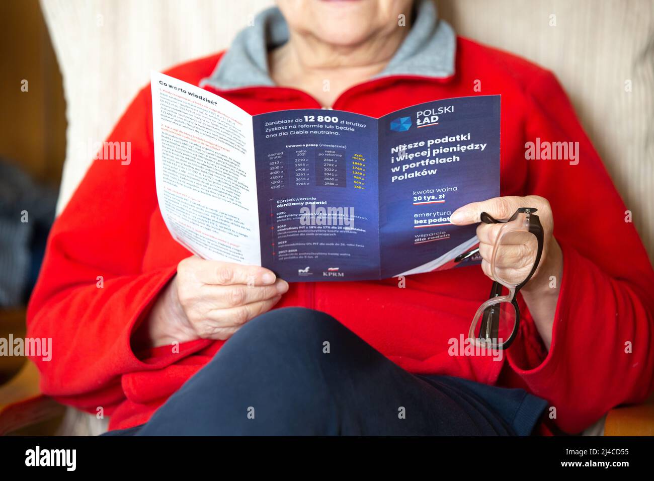 Poznan, Poland- March 3,2022: Illustrative editorial of a unidentified senior woman reading 'Polski Lad' (Polish Order) pamphlet. Stock Photo