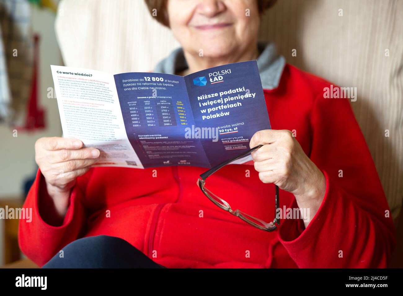 Poznan, Poland- March 3,2022: Illustrative editorial of a unidentified senior woman reading "Polski Lad" (Polish Order) pamphlet. Stock Photo