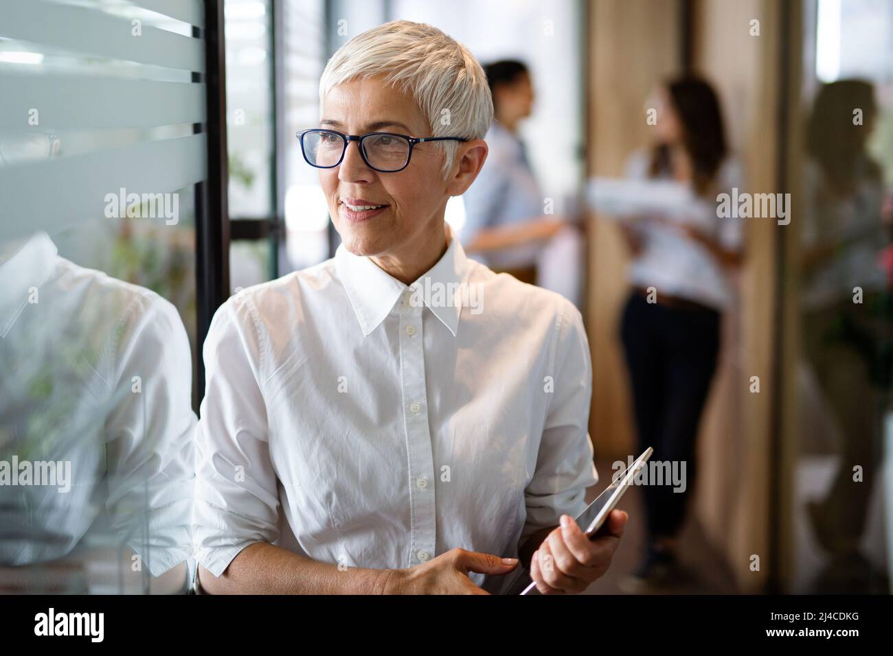 Mature business woman standing hi-res stock photography and images - Alamy