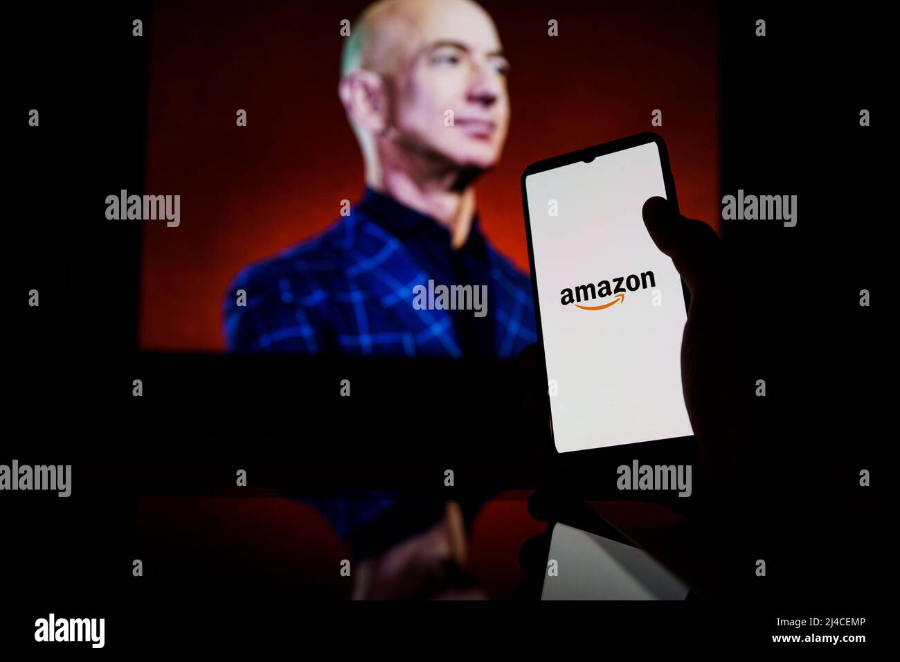 Amazon logo on screen and Jeff Bezos is a Executive Chairman of Amazon in background Stock Photo